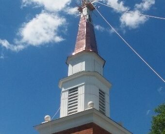 steeplejacks installing new copper and restored cross to steeple